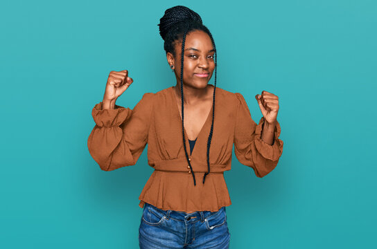 Young african american woman wearing casual clothes showing arms muscles smiling proud. fitness concept.