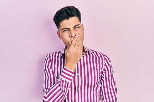 Young hispanic man wearing casual clothes bored yawning tired covering mouth with hand. restless and sleepiness.