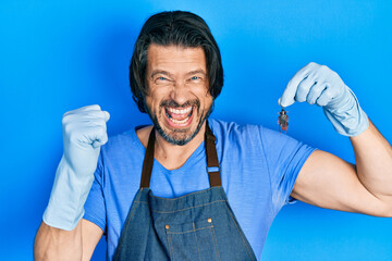 Middle age caucasian man holding cockroach screaming proud, celebrating victory and success very...