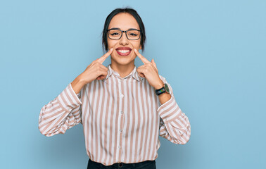 Young hispanic girl wearing casual clothes and glasses smiling with open mouth, fingers pointing and forcing cheerful smile