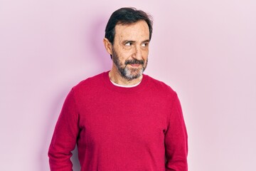 Middle age hispanic man wearing casual clothes smiling looking to the side and staring away thinking.