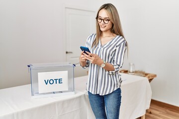 Young chinese woman using smartphone voting at electoral college