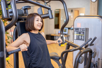 スポーツジムで体を鍛える女性（笑顔）
