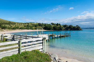 Summertime at the waterfront of a small island near Auckland, New Zealand. Blue sky, blue water, sea, beach, peaceful view.