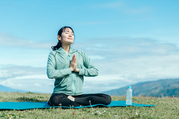 屋外でヨガをする女性（合掌）
