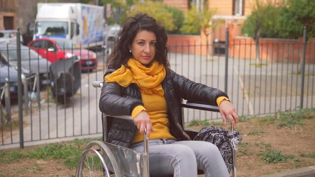 living with a disability - young beautiful woman with paraplegia stares serious at camera