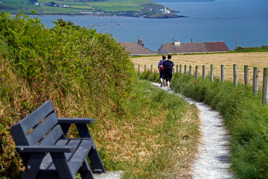 Crosshaven, County Cork, Ireland - Men walking on a countryside path with sea view