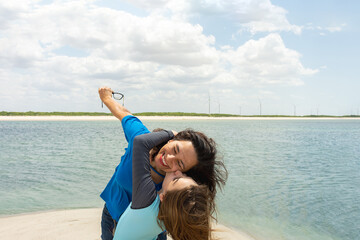 Filha feliz beijando a mãe em frente ao mar