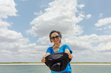 Mulher morena feliz na praia com céu azul 