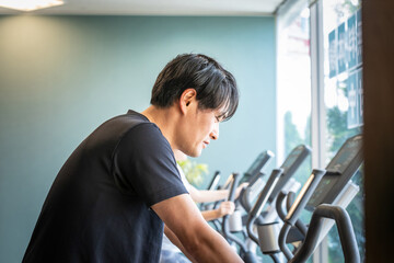 Fototapeta premium エアロバイクで運動する男性 