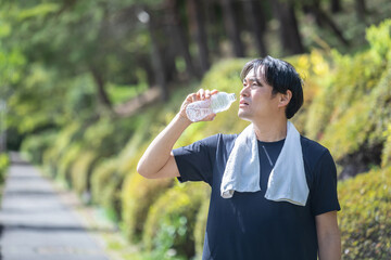 屋外でトレーニングする男性（水を飲む）
