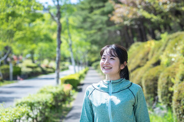 Fototapeta premium 緑の中でウォーキングする女性 