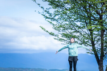 絶景の中にいるスポーツウェアの女性（深呼吸）
