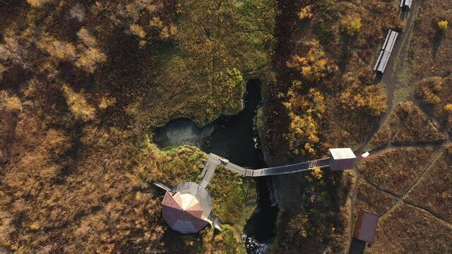 Drone video descending on female lying near hot spring and wooden house. Nalychevo, Kamchatka