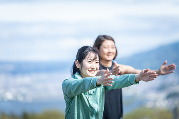 自然の中でスクワットをする女性たち（空）
