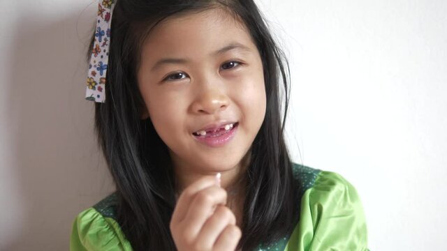 Asian girl children smiling with the baby teeth that have come out, dental concept.
