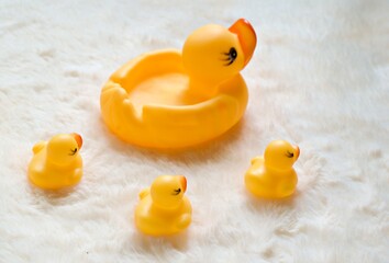 cute toy yellow rubber duck on white fur surface
