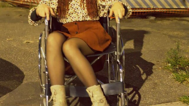wheelchair user - young man pushing her girfriend with disability among the many obstacles in the city streets
