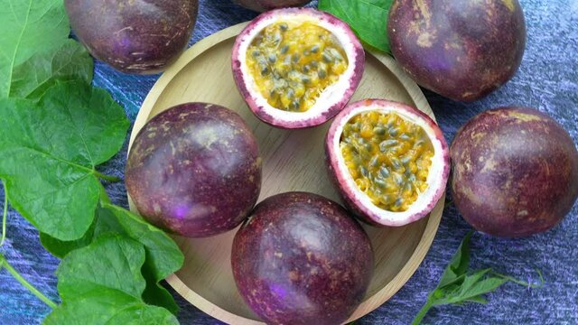Top view Passion fruit in wooden plate, Purple Passion fruit or Maracuya with leaf on a wooden table, 4k resolution.