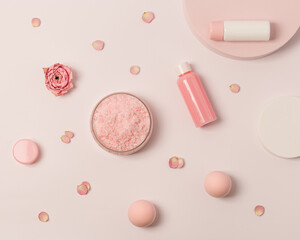 Rose scented sea salt in jar with small bottles shower gel, soap and rose flowers on round podium. Cosmetic product top view