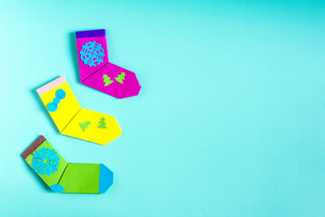 Bright Christmas decor, colorful socks made of paper on a colored background place for text.
