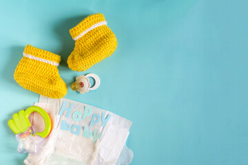 A set of things for a small child on a colored background of the copy space. Baby diapers, knitted...