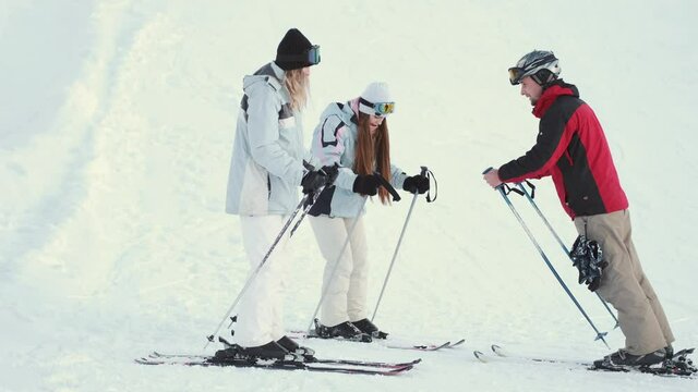 Ski instructor teaching two young women friends to ski at resort
