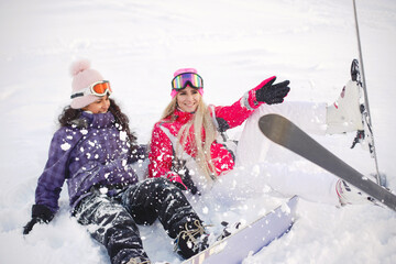 Group of girls spend time together skiing in mountains