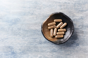 Ashwagandha (Withania somnifera) capsules. Bright wooden background. Top view. Close up. Copy...