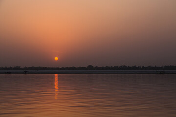 Naklejka premium インド ヴァラナシの早朝のガンジス川と朝日でオレンジ色に染まった空