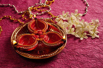 Clay Diya lamps lit with colorful garland during Diwali Celebration. Greetings Card Design Indian Hindu Light Festival called Diwali