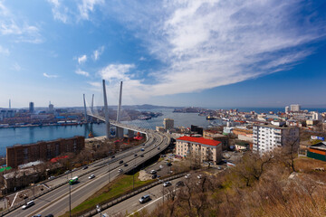 Fototapeta na wymiar Autumn, 2017 - Vladivostok, Russia - Golden Bridge over the Golden Horn Bay in Vladivostok. Cable-stayed bridge in Vladivostok. Cars drive along the roadway of the Golden Bridge.
