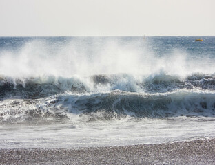 natural view of strong waves hitting the shore at summertime © Muzsek/Wirestock