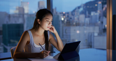 Woman study on tablet computer in the evening