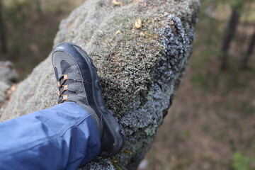 men's shoes on a rock background, a man traveling on rocks, a man's foot in a mountain boot on a rock background at a height, hiking in the mountains in boots