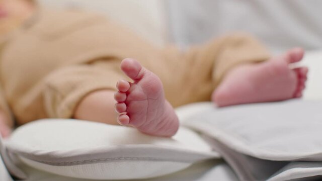 Close up barefoot of newborn baby lying on baby bed relax and comfortable.Infant Baby tiny feet moving on bed at home.Newborn Baby photography concept