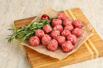 Raw uncooked beef meatballs served rosemary