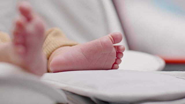 Close up barefoot of newborn baby lying on baby bed relax and comfortable.Infant Baby tiny feet moving on bed at home.Newborn Baby photography concept