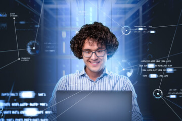 Smiling programmer portrait in glasses, sitting in front of lapt