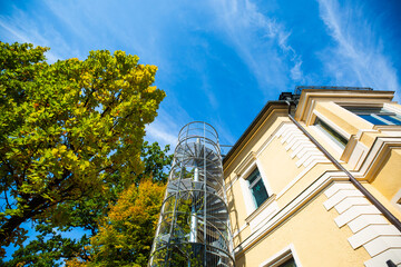 Spiral staircase on the house, blue sky, autumn