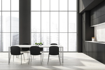 Black kitchen interior with eating table and kitchen set near window