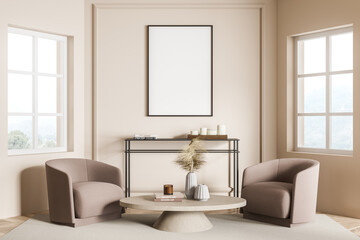 Empty frame on beige living room wall and two armchairs. Seating idea