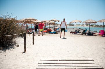 A photo of a public beach in Crete, white sand beach and people blurred at the background