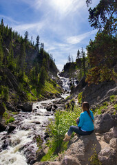 Rear view of a woman hiker resting in Yellowstone National Park, USA