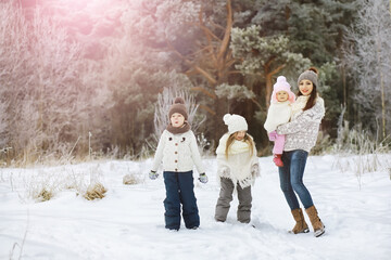 Happy family playing and laughing in winter outdoors in the snow. City park winter day.