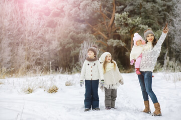 Happy family playing and laughing in winter outdoors in the snow. City park winter day.