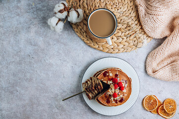 Fresh homemade pancakes with almonds, raspberry and coffee on white kithen background. Cozy breakfast