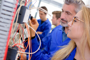 Young female trainee learning wiring
