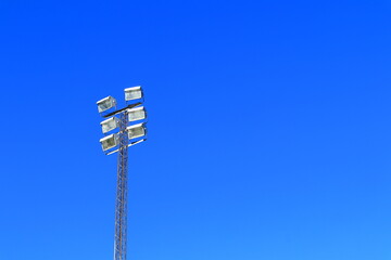 Large spotlight or searchlight. Above a soccer field. Clear blue sky. Stockholm, Sweden, Europe.