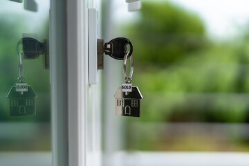 The house key is inserted in the door. Selling and renting a house concept
